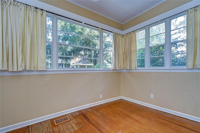 unfurnished room featuring crown molding and hardwood / wood-style floors