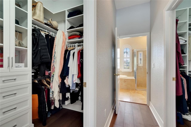 walk in closet with dark tile floors