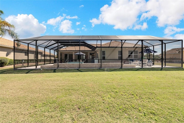 rear view of house with a lanai, a yard, and a patio area