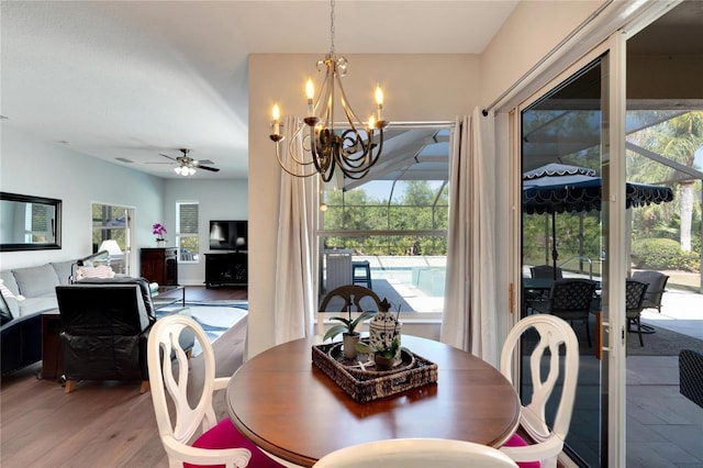 dining area with wood-type flooring and ceiling fan with notable chandelier