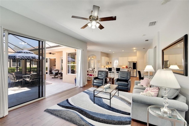 living room with ceiling fan and light hardwood / wood-style flooring