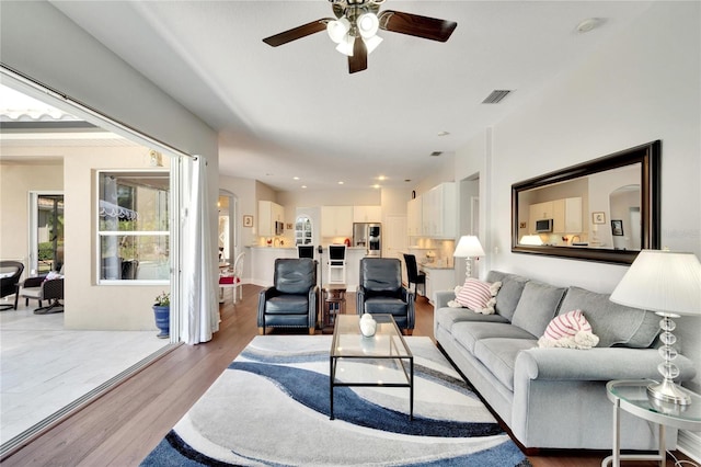 living room with light tile floors and ceiling fan