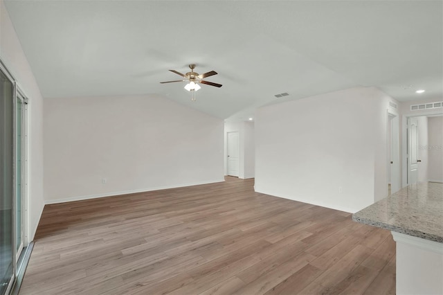 spare room with light hardwood / wood-style floors, ceiling fan, and lofted ceiling