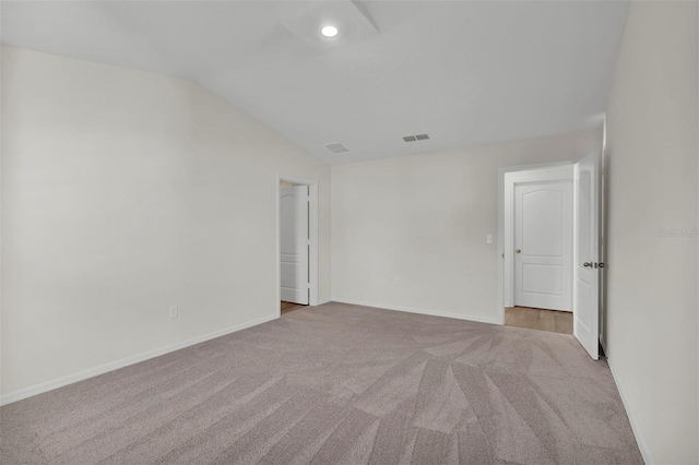 spare room with lofted ceiling and dark carpet