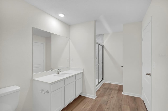 bathroom with hardwood / wood-style floors, large vanity, toilet, and walk in shower