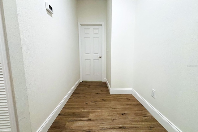 hallway with dark hardwood / wood-style flooring