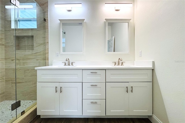 bathroom with tiled shower and vanity