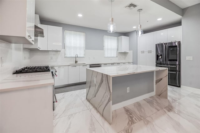 kitchen with hanging light fixtures, white cabinets, backsplash, stainless steel appliances, and light tile flooring