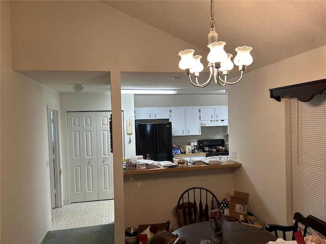 kitchen with stove, white cabinets, pendant lighting, an inviting chandelier, and black refrigerator