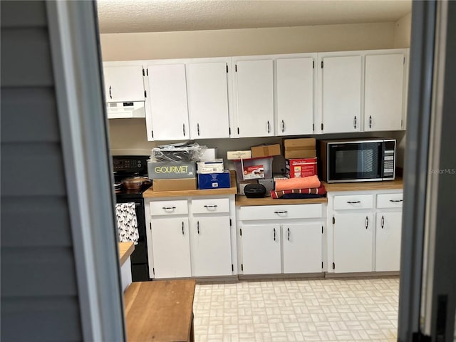 kitchen with white cabinets, range hood, black microwave, and electric range oven