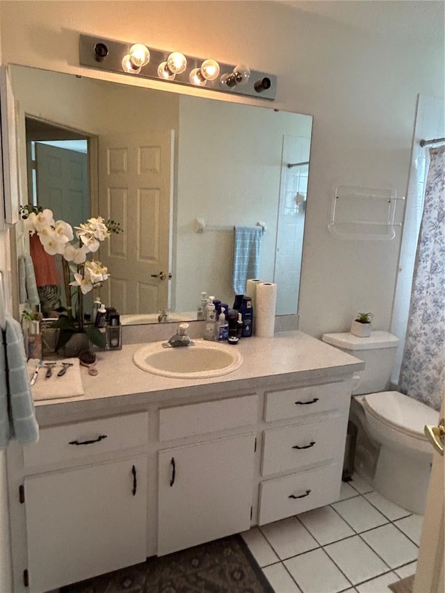 bathroom with tile flooring, vanity, and toilet