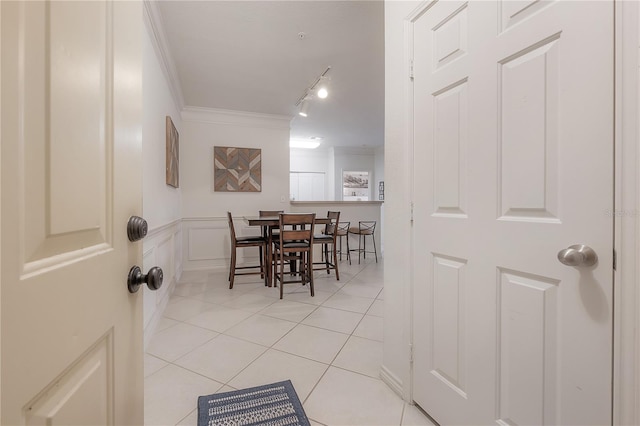 tiled dining area featuring crown molding and rail lighting