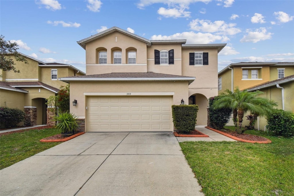 view of front of home with a front yard and a garage