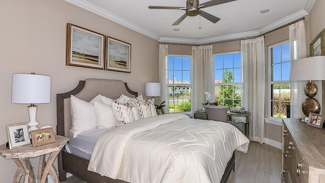 bedroom featuring crown molding, light hardwood / wood-style floors, and ceiling fan