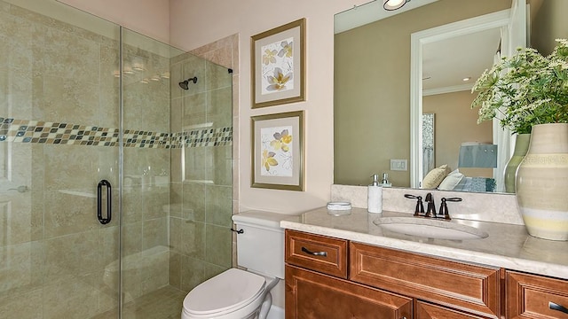 bathroom featuring vanity, crown molding, toilet, and walk in shower