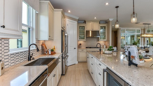 kitchen featuring light stone countertops, decorative light fixtures, sink, wine cooler, and tasteful backsplash