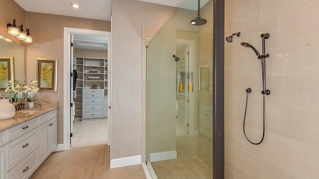 bathroom with an enclosed shower, vanity, and tile floors