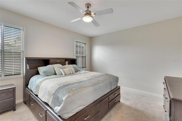 bedroom with light carpet, a ceiling fan, and baseboards