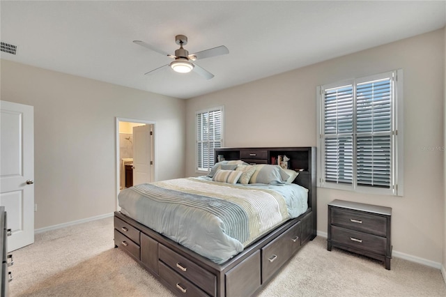 bedroom with baseboards, ceiling fan, ensuite bathroom, and light colored carpet