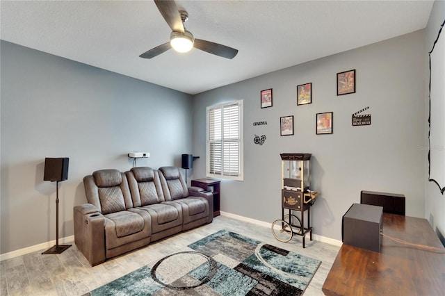 living room featuring a ceiling fan, light wood-style floors, and baseboards