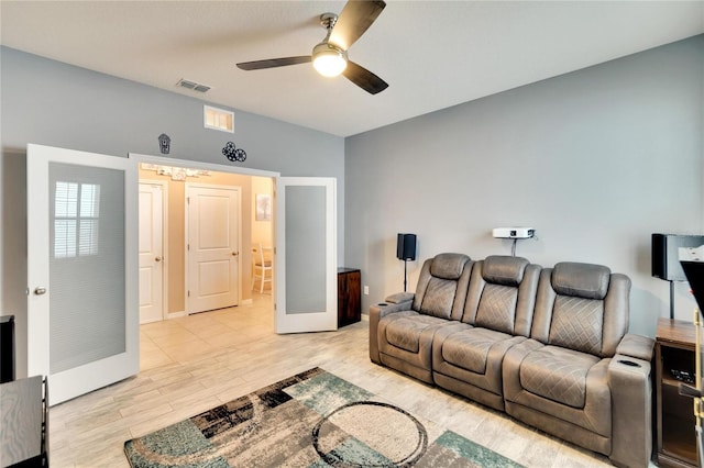 living room featuring light wood-style flooring, visible vents, and a ceiling fan