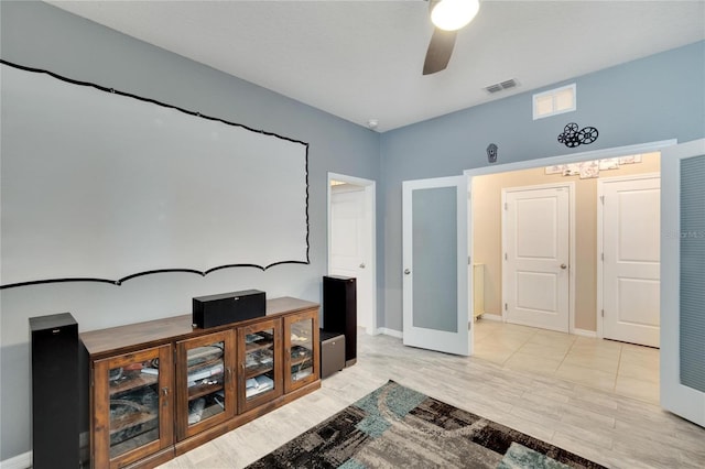 home theater featuring ceiling fan, visible vents, and baseboards