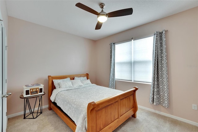 bedroom with baseboards, ceiling fan, and light colored carpet