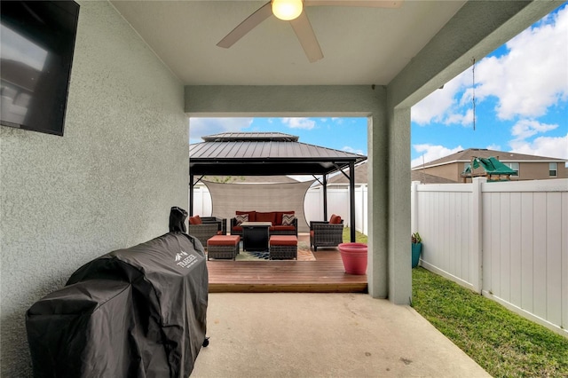 view of patio featuring a gazebo, ceiling fan, a fenced backyard, an outdoor living space, and a wooden deck