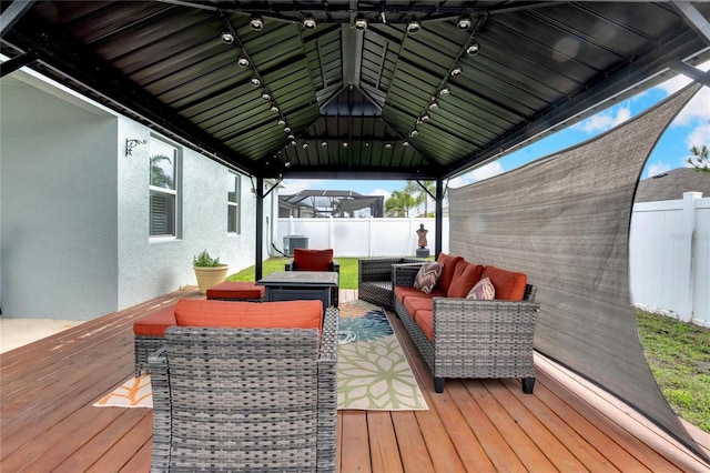 deck with central air condition unit, fence, an outdoor living space, and a gazebo