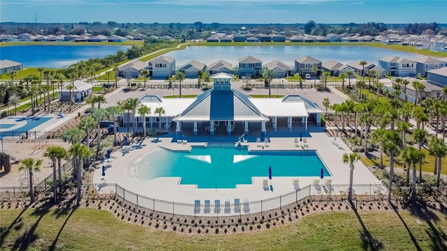 view of pool with a residential view, a water view, and fence