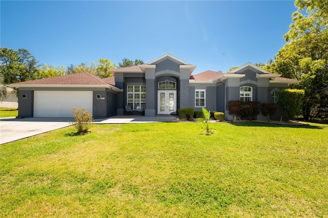 view of front facade featuring a front yard, a garage, and french doors