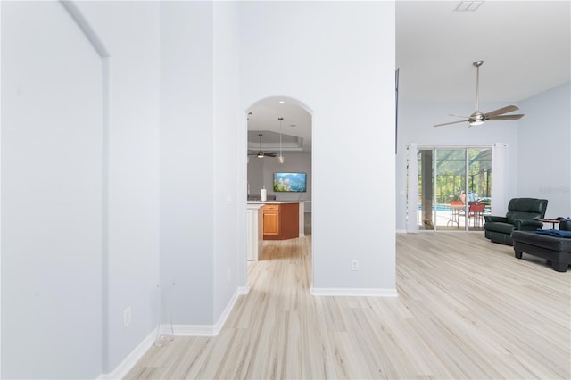 corridor featuring light hardwood / wood-style flooring and high vaulted ceiling