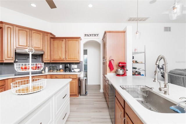 kitchen with pendant lighting, stainless steel dishwasher, ceiling fan, backsplash, and sink