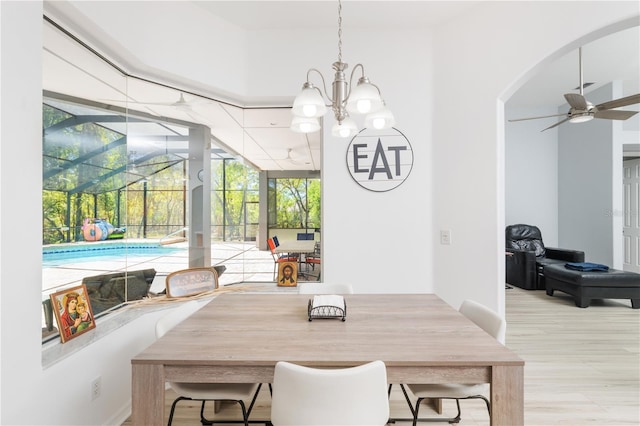 dining room featuring light wood-type flooring and ceiling fan with notable chandelier