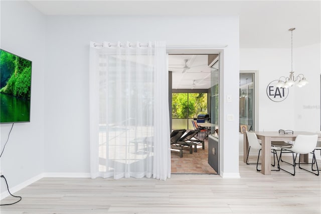 interior space featuring light wood-type flooring and an inviting chandelier