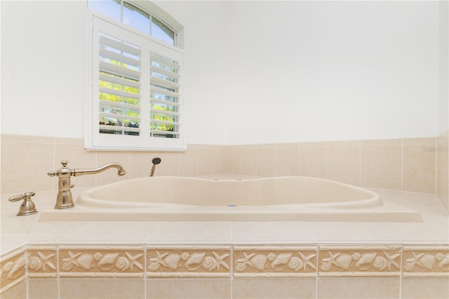 bathroom with tiled tub and a wealth of natural light