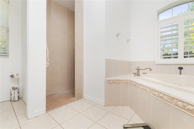 bathroom featuring tile flooring and tiled tub