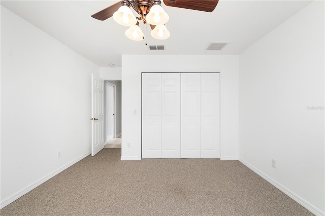 unfurnished bedroom with light carpet, a closet, and ceiling fan