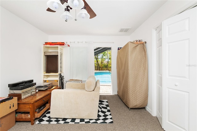 interior space featuring light carpet and ceiling fan with notable chandelier