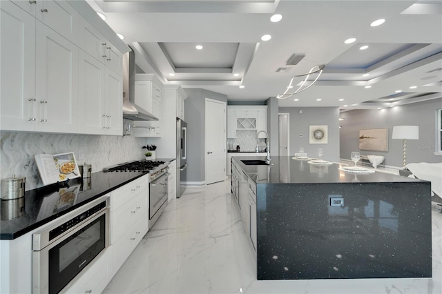 kitchen with light tile floors, tasteful backsplash, a raised ceiling, white cabinetry, and high end appliances