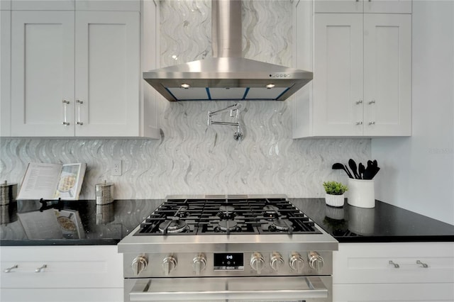 kitchen with tasteful backsplash, wall chimney range hood, and white cabinets