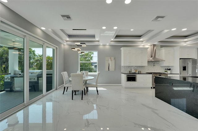 dining room featuring a raised ceiling and light tile floors