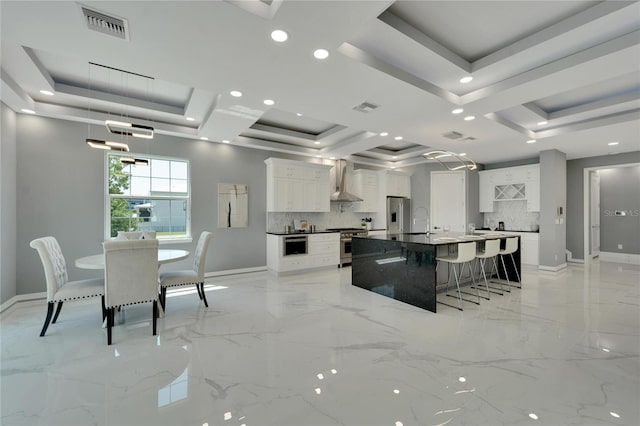 kitchen with white cabinets, a tray ceiling, and backsplash