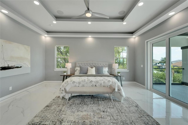 bedroom with access to exterior, light tile floors, and a tray ceiling