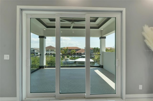 doorway to outside featuring plenty of natural light and a raised ceiling