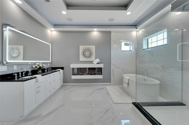 bathroom with separate shower and tub, large vanity, dual sinks, a tray ceiling, and tile floors