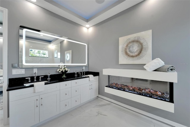 bathroom with a tray ceiling and double sink vanity