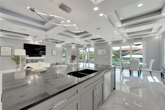 kitchen with sink, coffered ceiling, dark stone counters, dishwasher, and ceiling fan