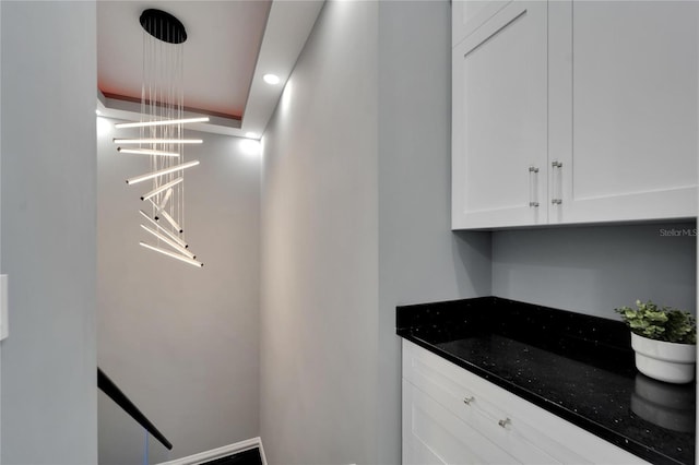 interior space with white cabinets and dark stone countertops