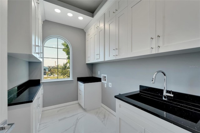 washroom featuring sink, light tile floors, washer hookup, and cabinets